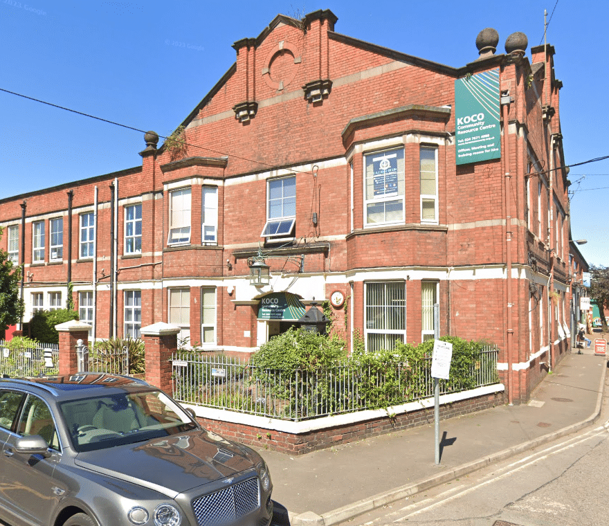 Outside shot of a two-storey red brick building. A green sign reads 'KOCO Community Resource Centre'.