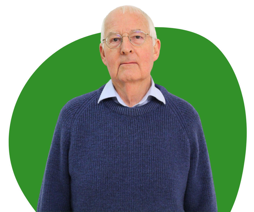 White male with white hair and glasses against a dark green background