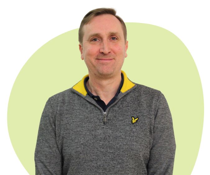 White man with short light brown hair against a green background.