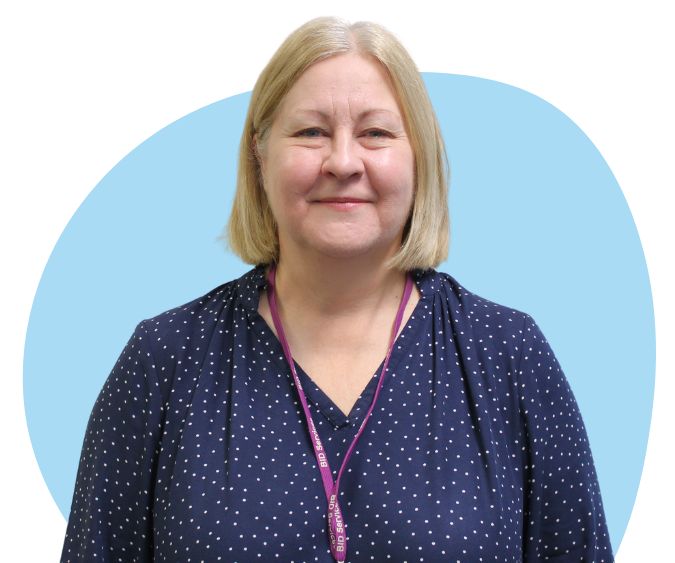 White woman with chin length blonde hair against a blue background.