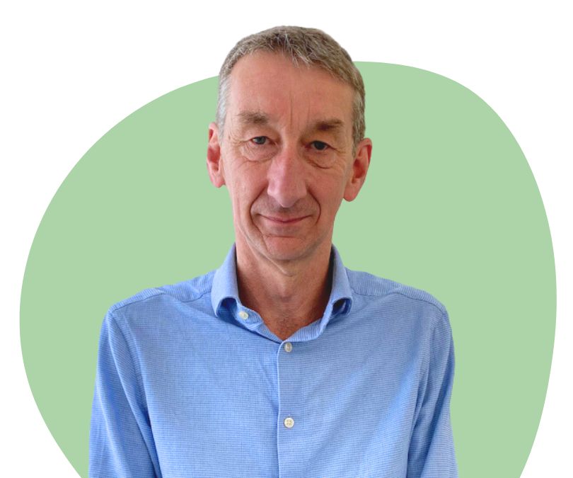 White man with short grey hair against a green background.