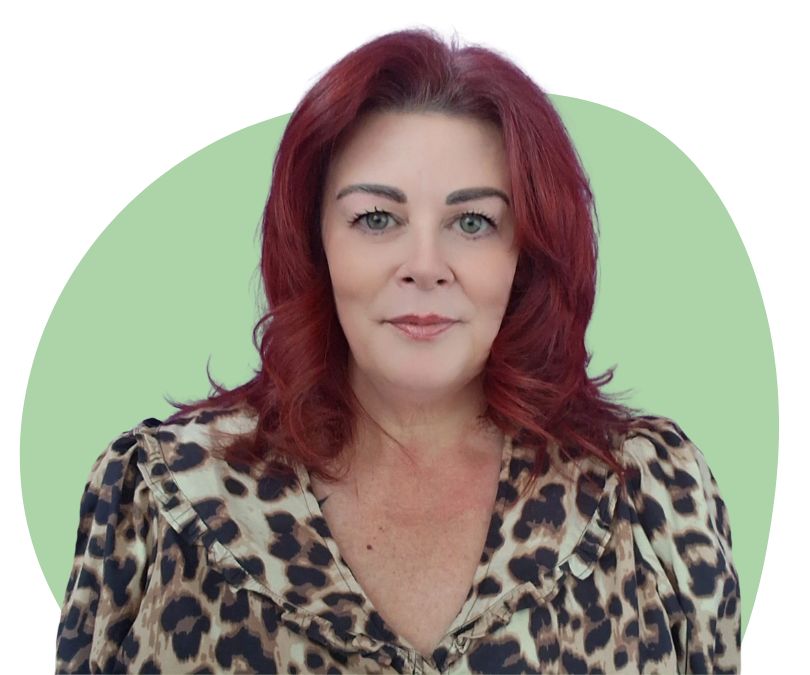 White woman with shoulder length red hair against a light green background.
