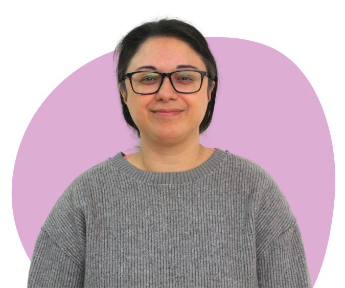 Asian woman with black hair and glasses against a purple background.