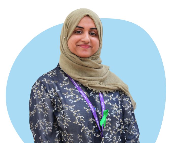 Asian woman wearing a hijab against a light blue background.