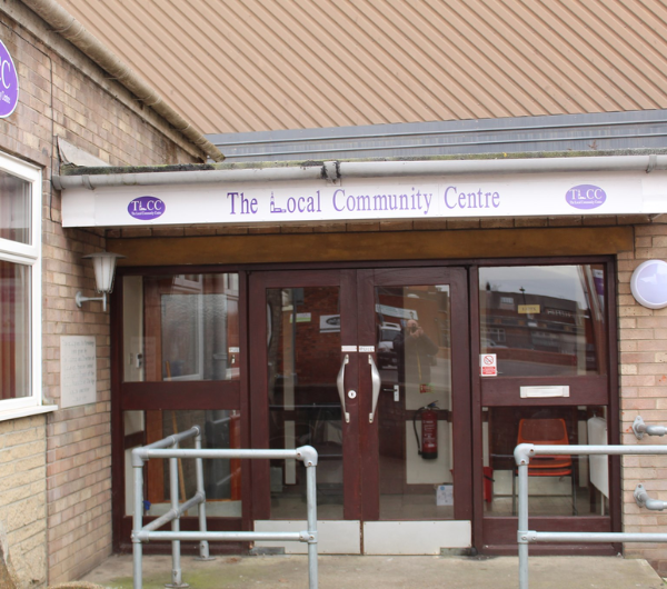 A beige brick building with dark brown framed windows and doors.