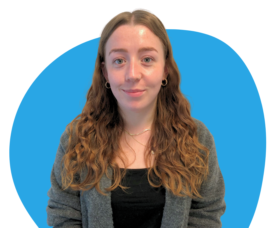 A white woman with long, wavy, dark red hair against a light blue background