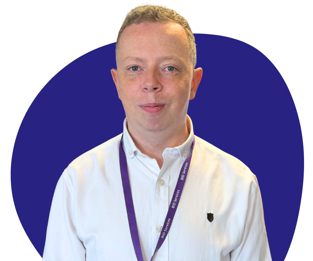 A white man with short grey hair against a dark blue background.