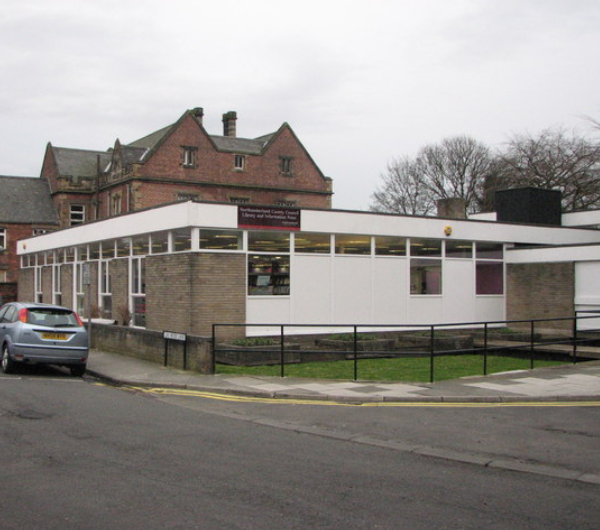 A single story building with grey bricks and panels of white.
