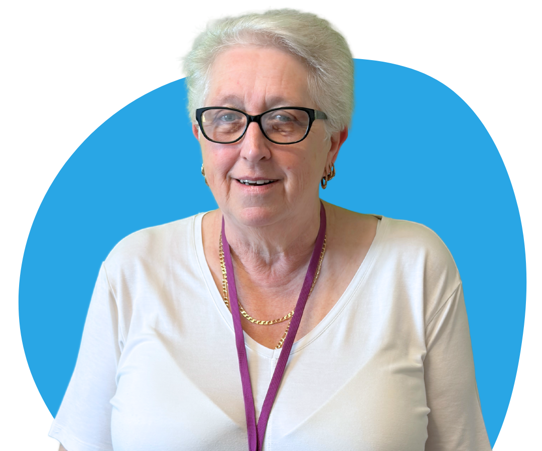 A white woman with short grey hair against a light blue background.