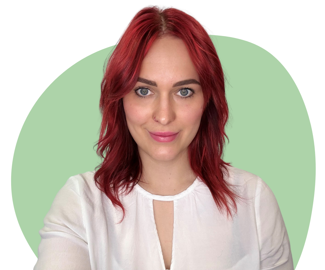 A white woman with shoulder length red hair against a dark green background.
