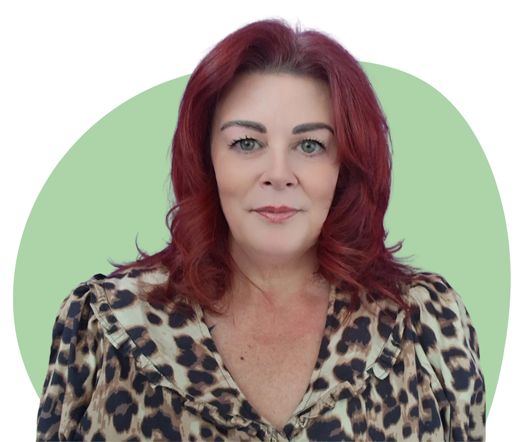 White woman with shoulder length red hair against a dark green background.